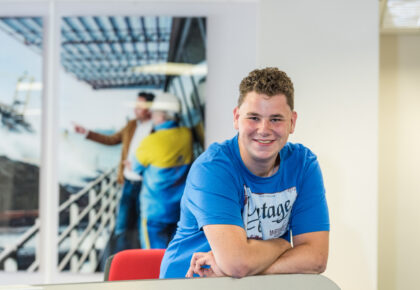 Foto van een jongen die achter een bureau zit